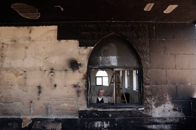 Two damaged mosques in the occupied West Bank after alleged arson attacks, with burn marks visible as investigators inspect the scene.