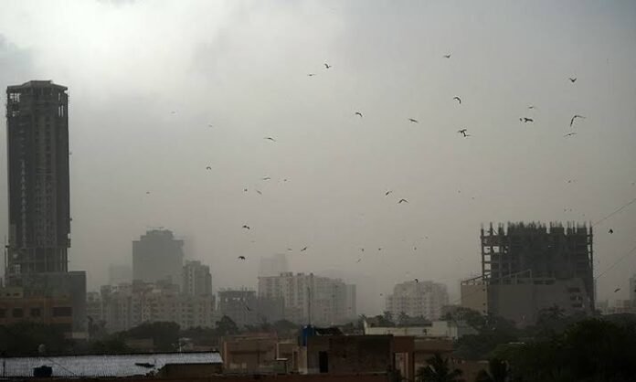 Dark storm clouds and a dust storm over Karachi as rain falls across several parts of the city, reducing visibility and cooling temperatures