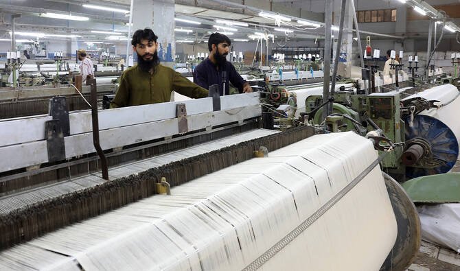 Workers in a modern Pakistani textile factory producing garments as the industry responds to evolving international standards.