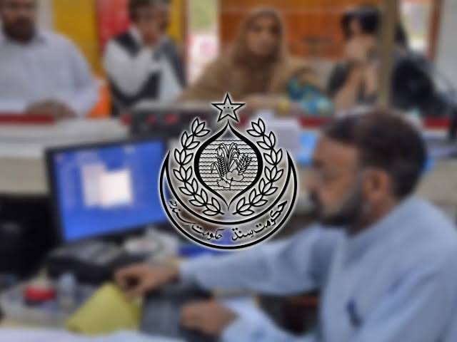 Government officers in a Sindh administrative office discussing official promotion documents and career decisions.